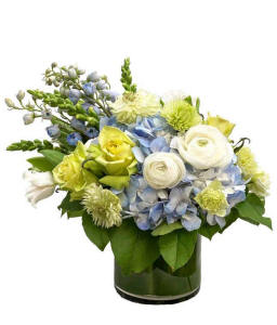 Blue and green floral arrangement in a glass vase