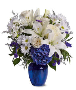 Blue hydrangea, white roses and white lilies in a blue vase