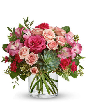 A vibrant floral arrangement featuring pink mini roses, pink alstroemeria, pink mini carnations, a succulent plant, and hot pink roses in deluxe and premium versions.