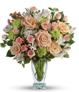 Anything For You bouquet with peach roses, peach spray roses, white alstroemeria, green carnations, peach hypericum, and a clear couture vase