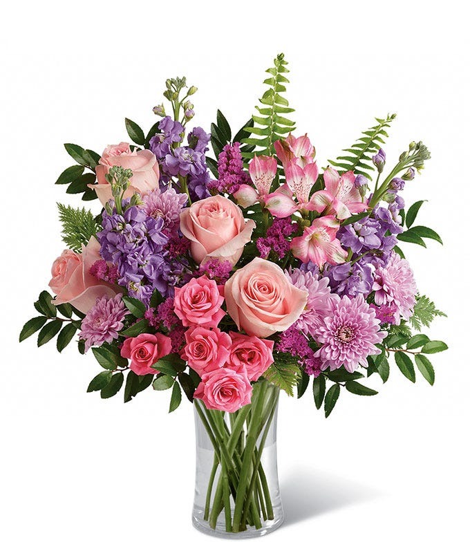 Soft pink and lavender Cherry Blossom Bouquet with roses, spray roses, alstroemeria, mums and greenery in a clear glass vase