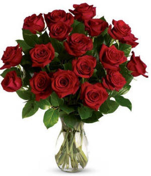 Classic red roses in a clear glass vase with greenery