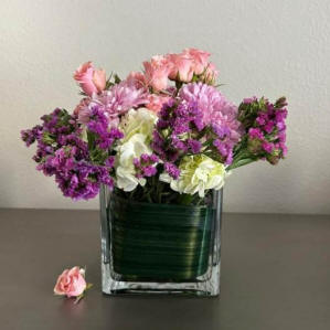 A square vase with purple flowers