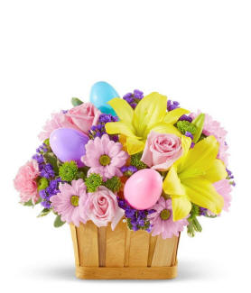 A basket filled with Easter eggs and flowers