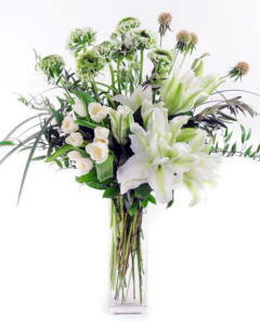 Elegance in White Locally-grown ranunculus and locally-grown rose lilies are combined with lush locally-grown greens and other textural elements in this jaw-dropper. Spring arrangement