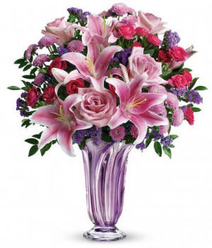 Pink roses and spray roses with pink oriental lilies and lavender mums in a designed keepsake vase