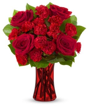 Red Romance Roses bouquet with red roses, miniature red carnations and greenery in a red glass vase