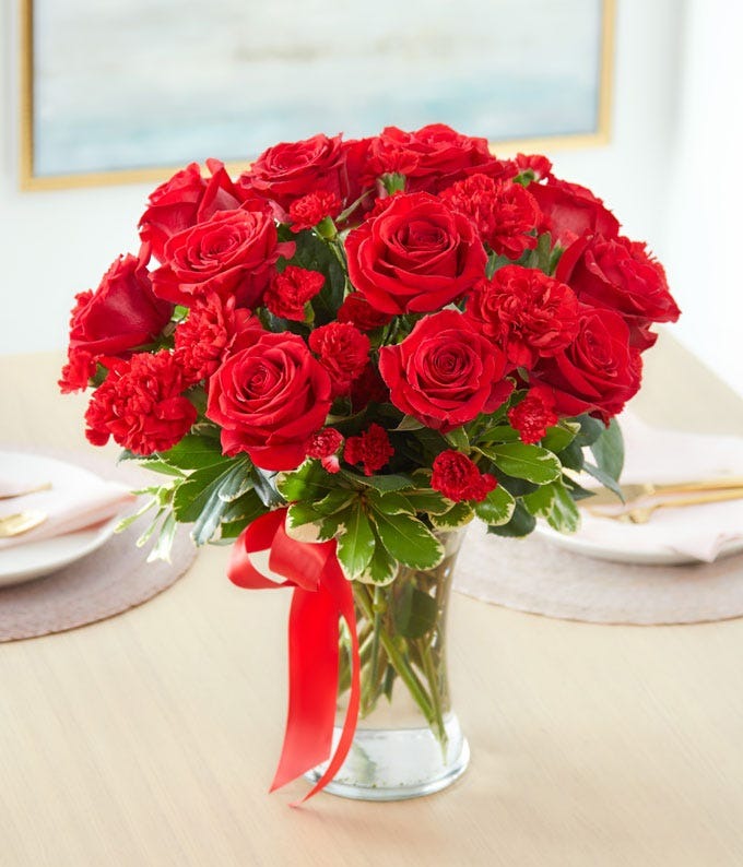 Your In My Heart bouquet with red roses and carnations in a clear glass vase with red ribbon