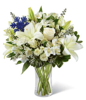Sculpted Ice Bouquet with white lilies, white roses, white spray roses, white alstroemeria, baby's breath, and a blue snowflake keepsake vase
