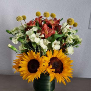A vase of sunflowers and other mixed flowers