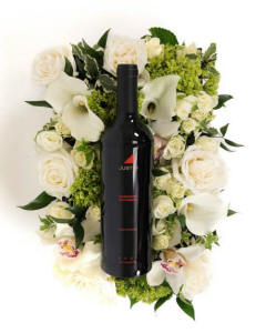  This stunning arrangement features a sophisticated mix of white and ivory roses, elegant calla lilies, and delicate orchids, all beautifully complemented by lush green accents.