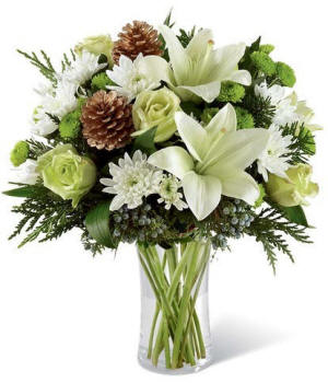 Wintery white lily arrangement with roses and seasonal accents in a vase, cozy elegant design